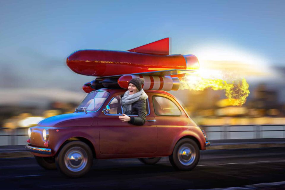 Kleines Auto fährt mit Rakete auf Dach