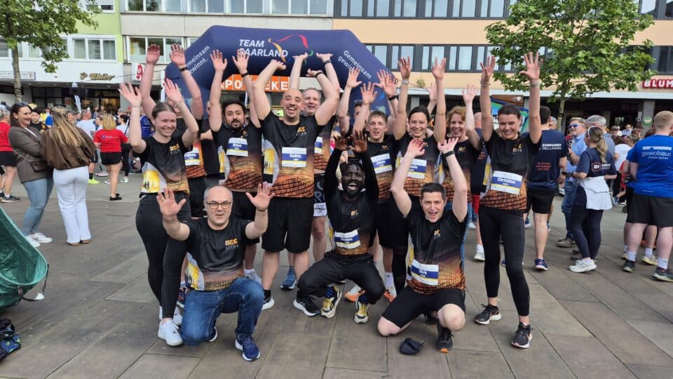 Das Bild zeigt ein Gruppenfoto von dem CLC Laufteam vor dem Start, alle tragen ein passenden Laufshirt und jubeln